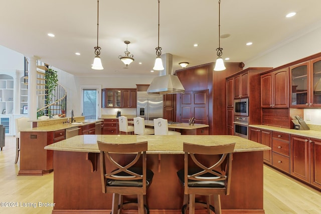 kitchen with built in appliances, hanging light fixtures, and a kitchen island