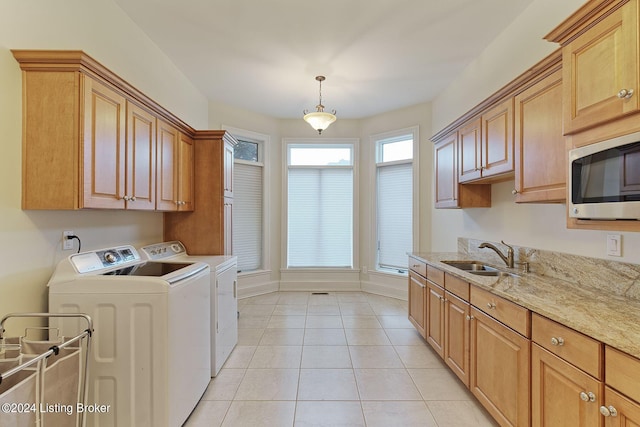 laundry area featuring cabinets, separate washer and dryer, sink, and light tile patterned floors