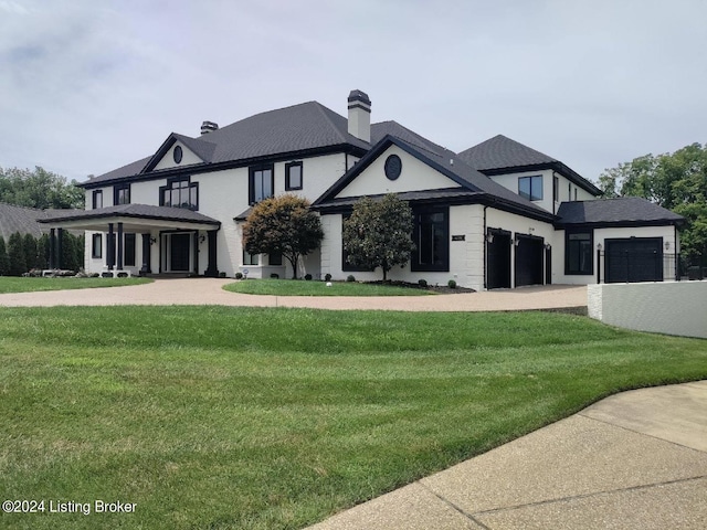 view of front of home with a garage and a front lawn