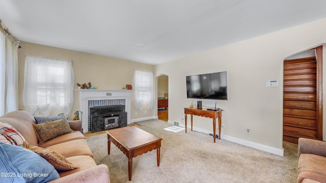 carpeted living room with a brick fireplace