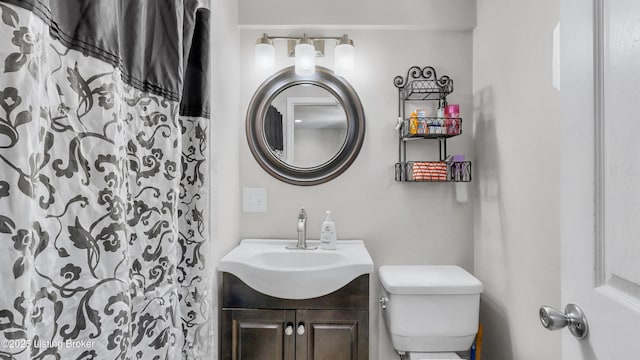 bathroom with vanity, curtained shower, and toilet