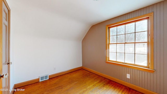 additional living space featuring lofted ceiling and light hardwood / wood-style floors