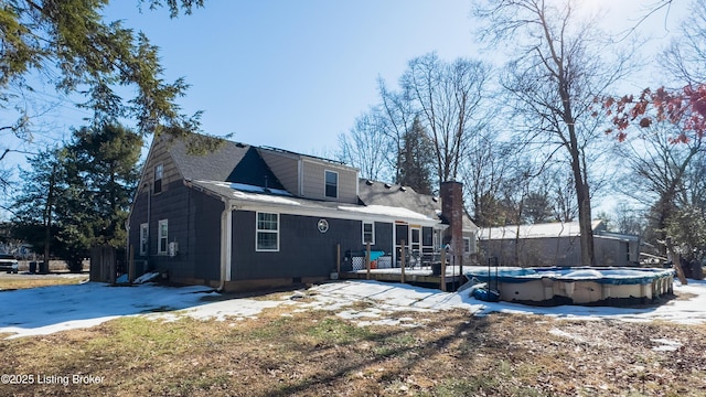 rear view of house with a swimming pool side deck