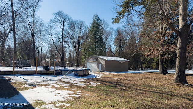 view of yard with a garage and an outbuilding