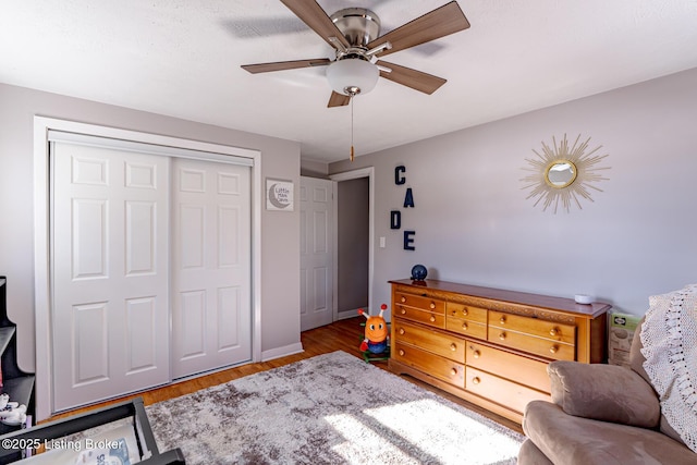 sitting room with ceiling fan and wood-type flooring