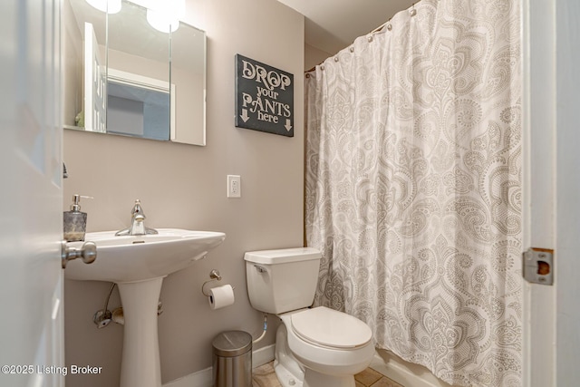 bathroom featuring a shower with shower curtain and toilet