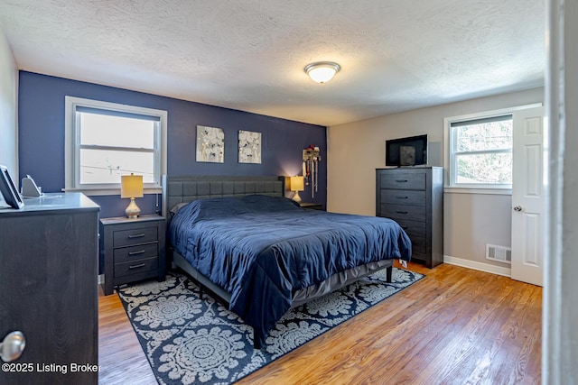 bedroom featuring a textured ceiling and light wood-type flooring