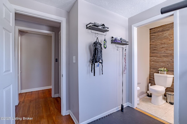 hallway with dark hardwood / wood-style floors and a textured ceiling