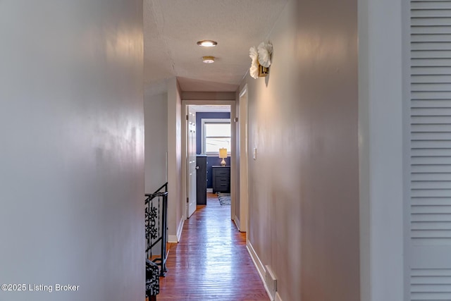 hallway with wood-type flooring and a textured ceiling