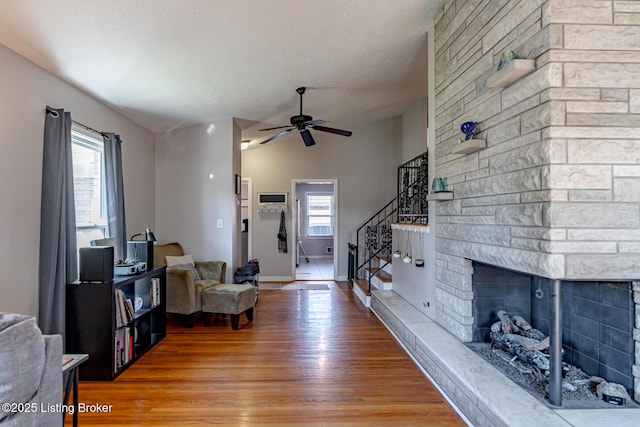 living room featuring hardwood / wood-style flooring, a fireplace, vaulted ceiling, and a wealth of natural light