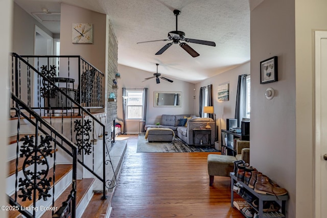 living room with lofted ceiling, hardwood / wood-style floors, and a textured ceiling