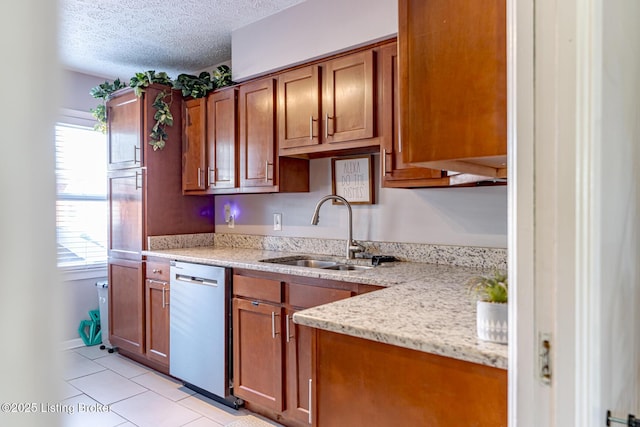 kitchen with light tile patterned flooring, sink, stainless steel dishwasher, light stone counters, and a textured ceiling