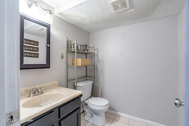 bathroom featuring vanity, toilet, tile patterned flooring, and a textured ceiling