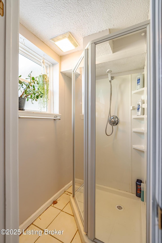 bathroom featuring tile patterned flooring, an enclosed shower, and a textured ceiling