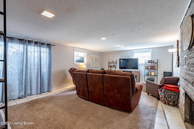 living room with light tile patterned floors, a wealth of natural light, a fireplace, and a textured ceiling