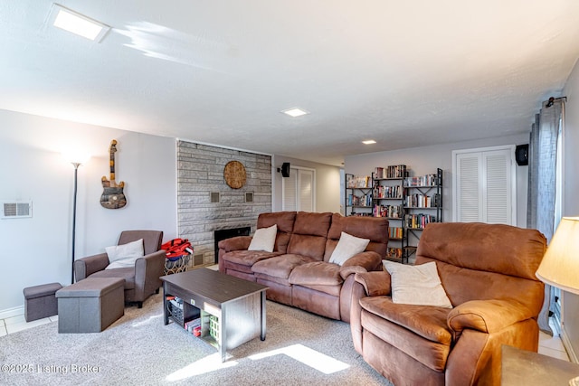 living room featuring a fireplace, light carpet, and a textured ceiling