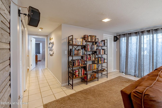 living area with light tile patterned flooring and a textured ceiling