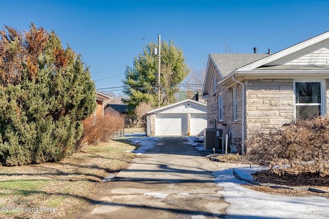 view of side of property featuring a garage, an outbuilding, and central AC unit