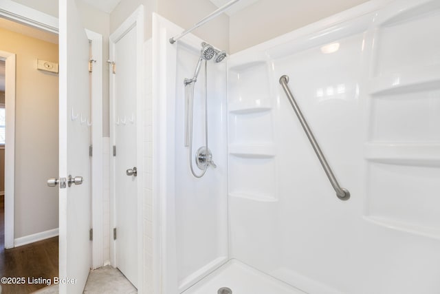 bathroom featuring hardwood / wood-style flooring and walk in shower