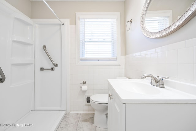 bathroom featuring tile walls, vanity, a shower, and toilet