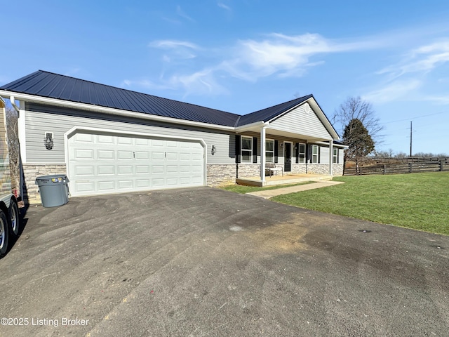 single story home featuring a garage, a porch, and a front yard