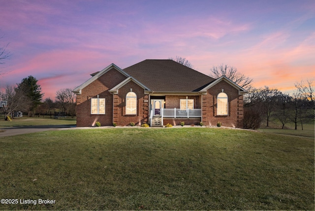 view of front of house with a porch and a yard