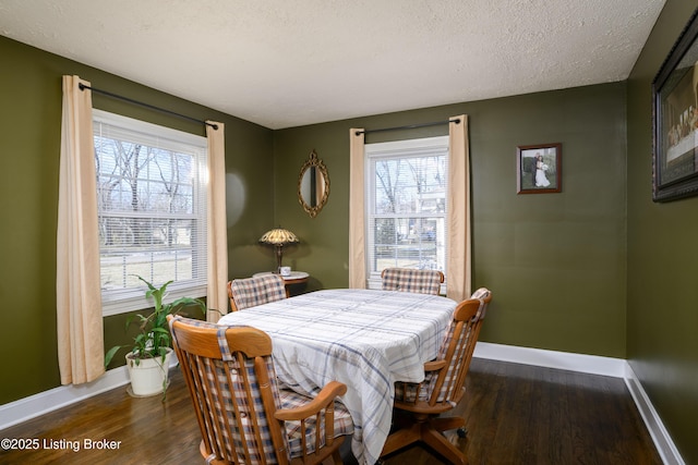 dining space featuring dark wood-type flooring and a textured ceiling