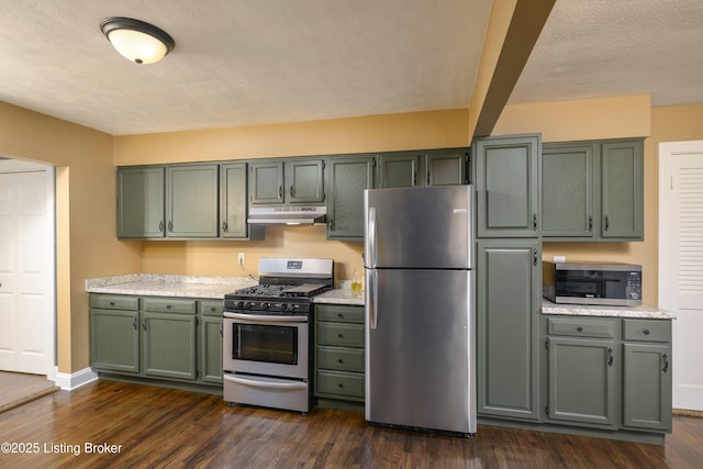 kitchen with stainless steel appliances, green cabinets, a textured ceiling, and dark hardwood / wood-style flooring