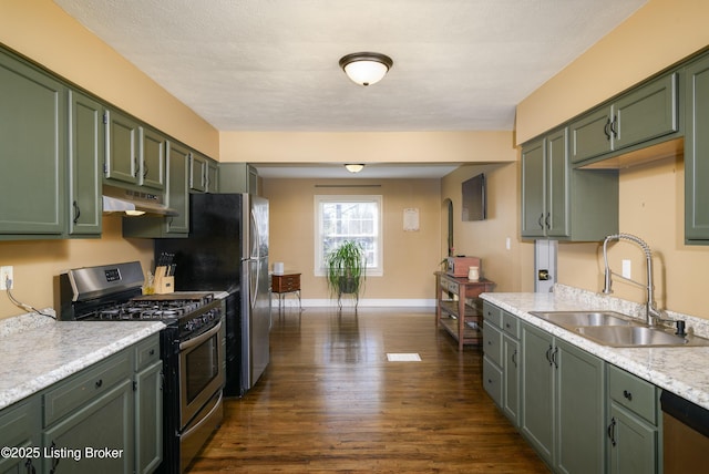 kitchen featuring appliances with stainless steel finishes, dark hardwood / wood-style floors, sink, green cabinets, and a textured ceiling