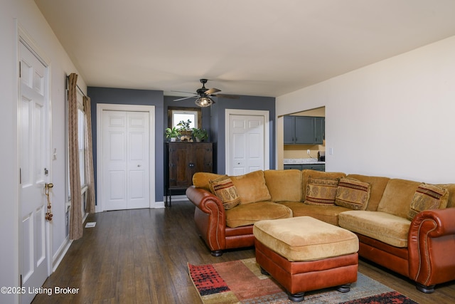 living room with ceiling fan and dark hardwood / wood-style flooring