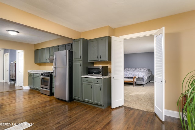 kitchen with appliances with stainless steel finishes and dark hardwood / wood-style floors