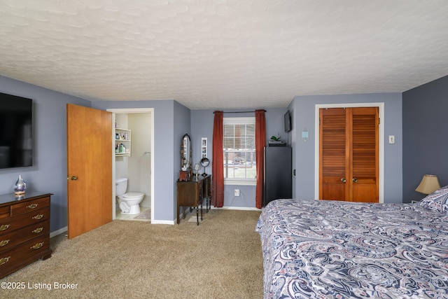 carpeted bedroom with connected bathroom, a textured ceiling, and a closet