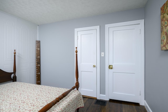 bedroom featuring dark hardwood / wood-style floors and a textured ceiling