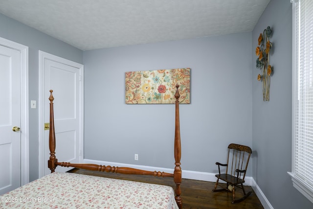 bedroom with dark wood-type flooring and a textured ceiling