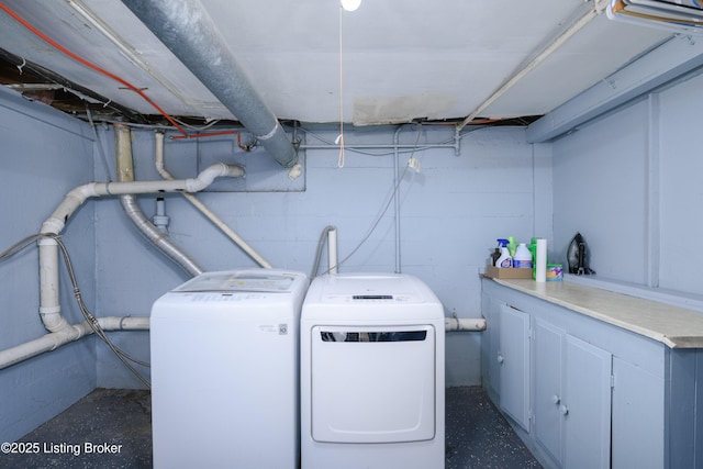 clothes washing area with cabinets and independent washer and dryer