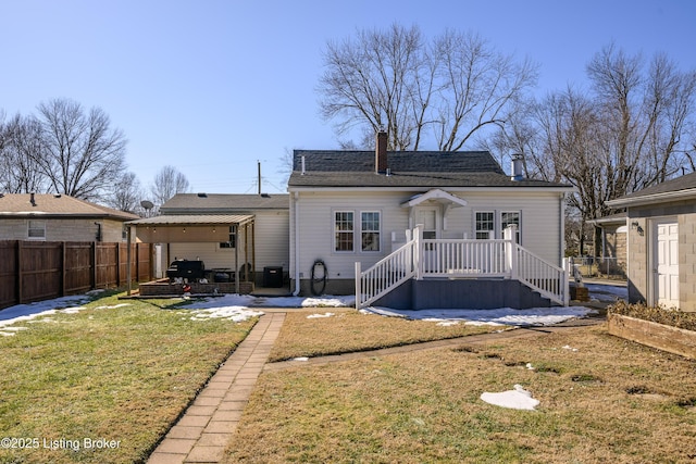 rear view of house with a patio and a lawn