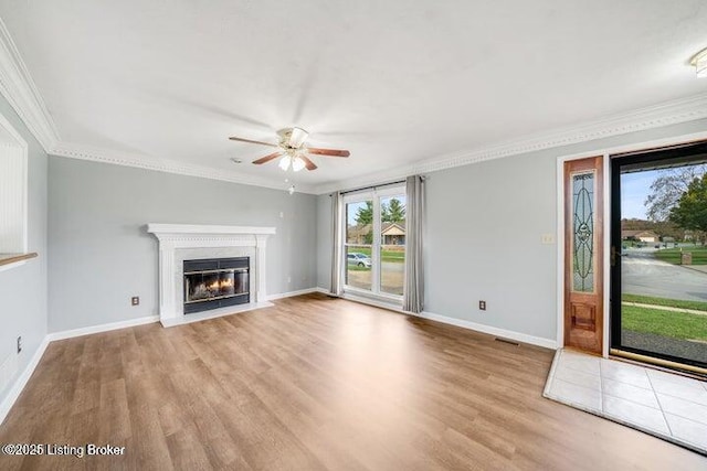 unfurnished living room featuring ceiling fan, ornamental molding, and light hardwood / wood-style floors