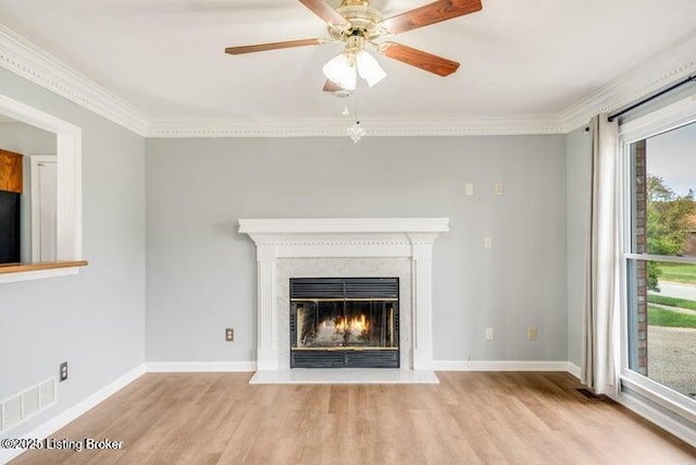 unfurnished living room featuring crown molding, ceiling fan, and light hardwood / wood-style floors