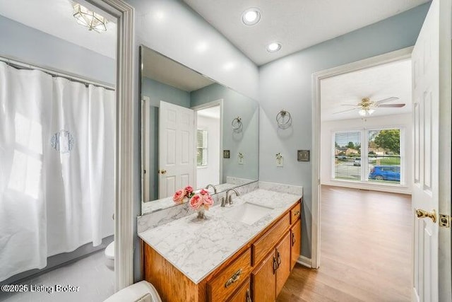 bathroom featuring vanity, hardwood / wood-style flooring, toilet, and ceiling fan