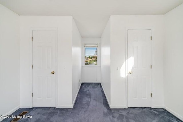 hallway with dark colored carpet