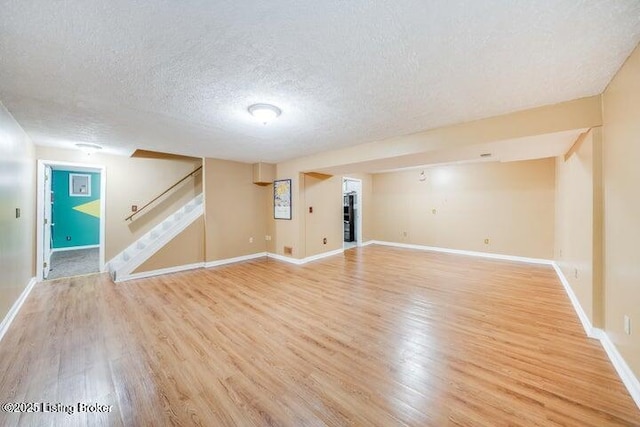 basement with light hardwood / wood-style floors and a textured ceiling