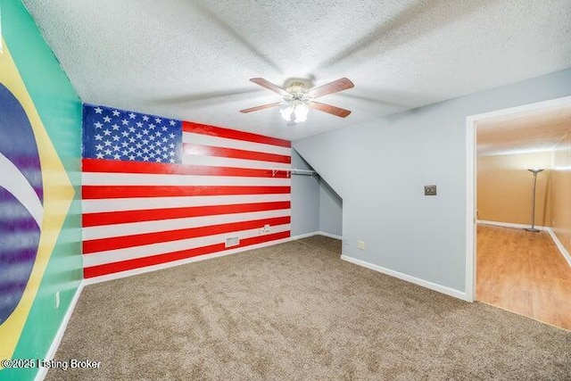 additional living space featuring lofted ceiling, ceiling fan, a textured ceiling, and carpet