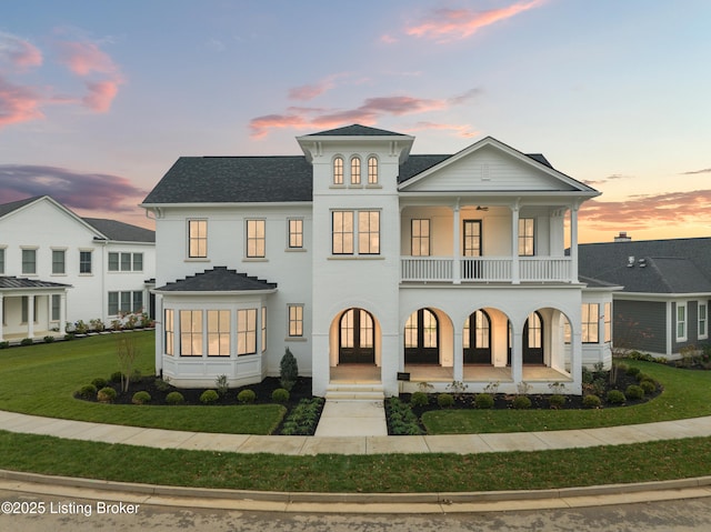 view of front of property with a lawn and a balcony