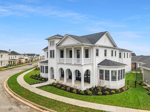 exterior space featuring a porch, a balcony, and a front yard