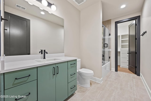 full bathroom with tile patterned flooring, vanity, combined bath / shower with glass door, and toilet