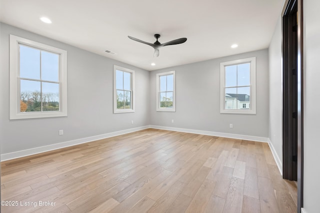 spare room featuring plenty of natural light, ceiling fan, and light wood-type flooring