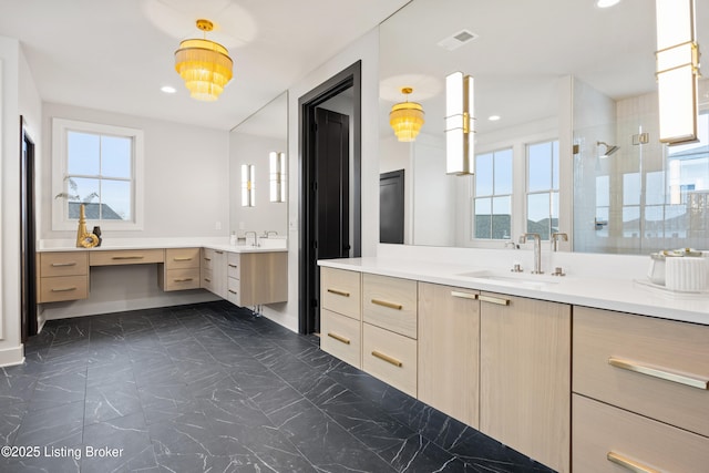 bathroom with a shower with door, vanity, and a wealth of natural light