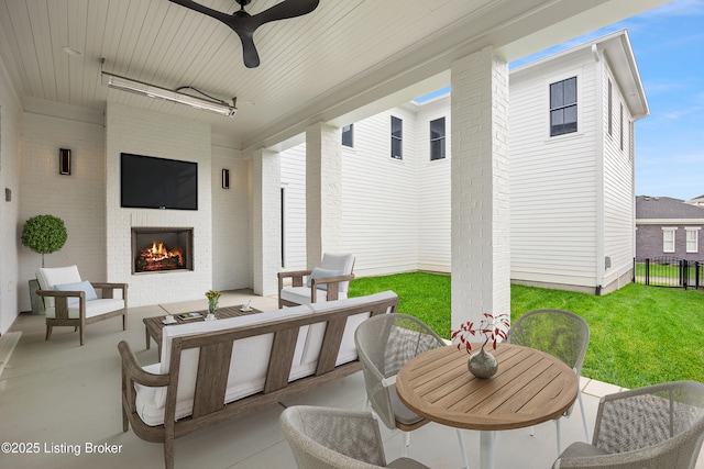 view of patio with an outdoor living space with a fireplace and ceiling fan