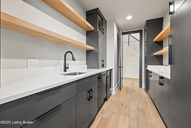 kitchen featuring dishwasher, sink, stainless steel fridge, and light wood-type flooring