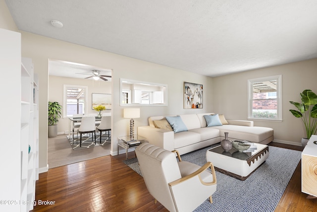 living room with ceiling fan, plenty of natural light, and dark hardwood / wood-style floors